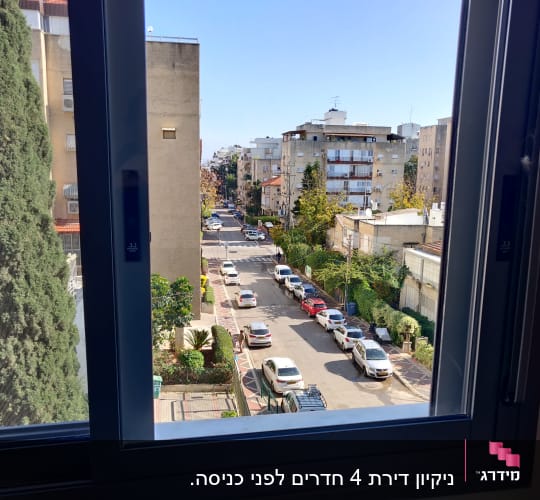 נוף עירוני מבעד לחלון פתוח עם מסגרת נקייה